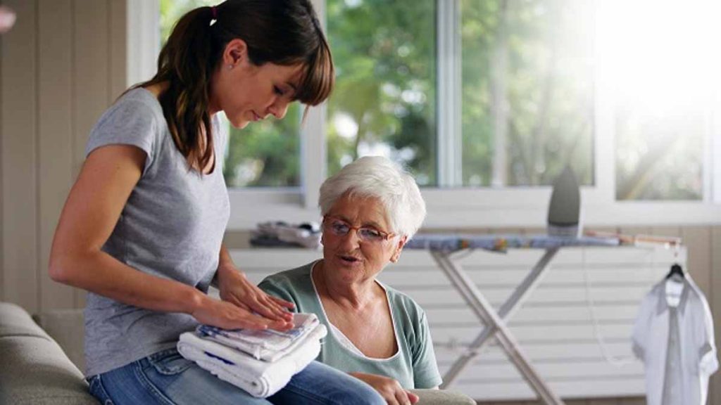 Auxiliaire de vie accompagnant une personne âgée à domicile.